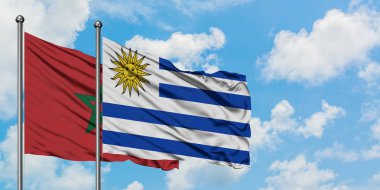 Fas ve Uruguay bayrağı birlikte beyaz bulutlu mavi gökyüzüne karşı rüzgarsal sallayarak. Diplomasi kavramı, uluslararası ilişkiler.