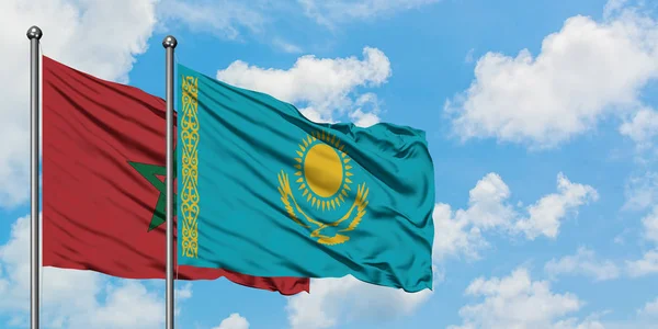 Bandera de Marruecos y Kazajstán ondeando en el viento contra el cielo azul nublado blanco juntos. Concepto diplomático, relaciones internacionales . — Foto de Stock