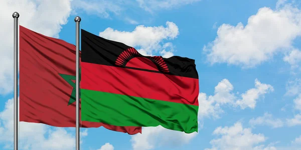 Bandera de Marruecos y Malawi ondeando en el viento contra el cielo azul nublado blanco juntos. Concepto diplomático, relaciones internacionales . — Foto de Stock