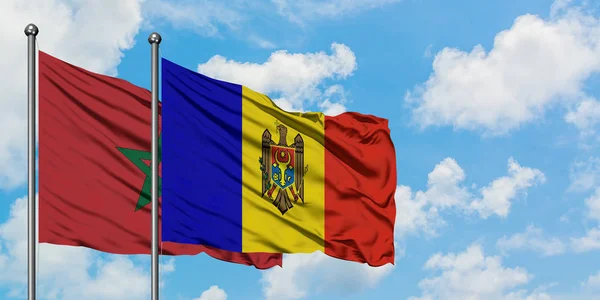 Marokko en Moldavië vlag zwaaien in de wind tegen witte bewolkte blauwe hemel samen. Diplomatie concept, internationale betrekkingen. — Stockfoto