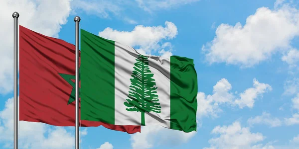 Bandera de Marruecos y Norfolk Island ondeando en el viento contra el cielo azul nublado blanco juntos. Concepto diplomático, relaciones internacionales . — Foto de Stock