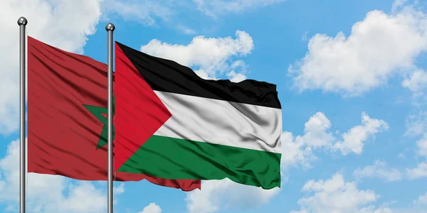 Bandera de Marruecos y Palestina ondeando en el viento contra el cielo azul nublado blanco juntos. Concepto diplomático, relaciones internacionales . — Foto de Stock