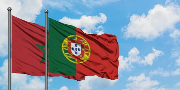 Bandeira de Marrocos e Portugal agitando no vento contra o céu azul nublado branco juntos. Conceito de diplomacia, relações internacionais . — Fotografia de Stock