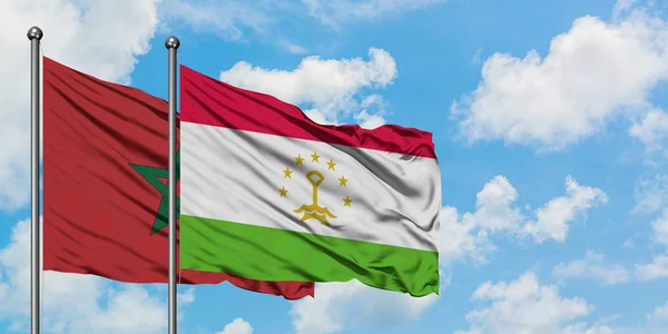 Bandera de Marruecos y Tayikistán ondeando en el viento contra el cielo azul nublado blanco juntos. Concepto diplomático, relaciones internacionales . — Foto de Stock