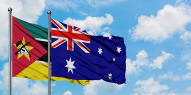 Mozambik ve Avustralya bayrağı birlikte beyaz bulutlu mavi gökyüzüne karşı rüzgarda sallayarak. Diplomasi kavramı, uluslararası ilişkiler.