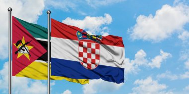 Mozambik ve Hırvatistan bayrağı birlikte beyaz bulutlu mavi gökyüzüne karşı rüzgarda sallayarak. Diplomasi kavramı, uluslararası ilişkiler.