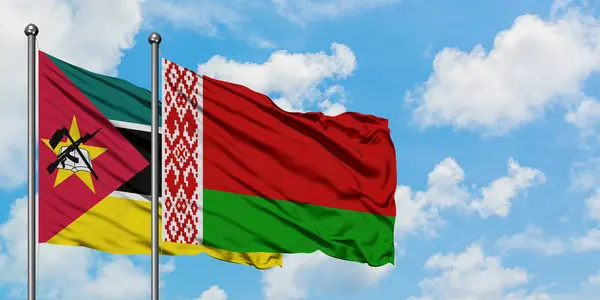 Mozambique en Wit-Rusland vlag zwaaien in de wind tegen witte bewolkte blauwe hemel samen. Diplomatie concept, internationale betrekkingen. — Stockfoto