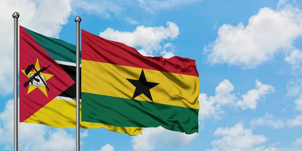一緒に白い曇り青い空に対して風に手を振るモザンビークとガーナの旗。外交概念、国際関係. — ストック写真