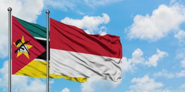 Mozambik ve Monako bayrağı birlikte beyaz bulutlu mavi gökyüzüne karşı rüzgarda sallayarak. Diplomasi kavramı, uluslararası ilişkiler.