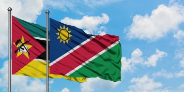 Mozambik ve Namibya bayrağı birlikte beyaz bulutlu mavi gökyüzüne karşı rüzgarda sallayarak. Diplomasi kavramı, uluslararası ilişkiler.
