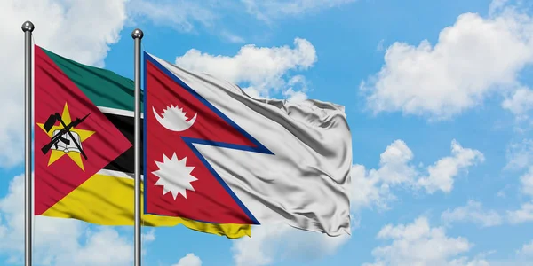 Bandera de Mozambique y Nepal ondeando en el viento contra el cielo azul nublado blanco juntos. Concepto diplomático, relaciones internacionales . — Foto de Stock