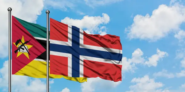 Bandera de Mozambique y Noruega ondeando en el viento contra el cielo azul nublado blanco juntos. Concepto diplomático, relaciones internacionales . — Foto de Stock