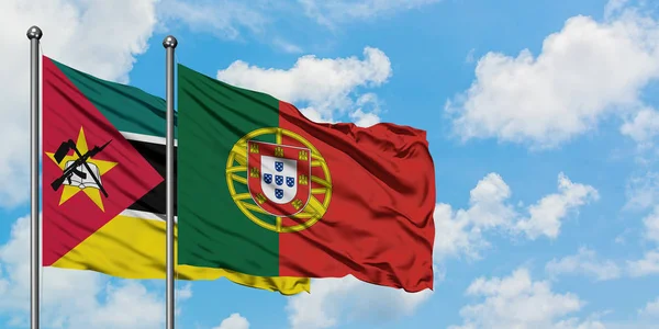 Mozambik ve Portekiz bayrağı birlikte beyaz bulutlu mavi gökyüzüne karşı rüzgarsal sallayarak. Diplomasi kavramı, uluslararası ilişkiler. — Stok fotoğraf