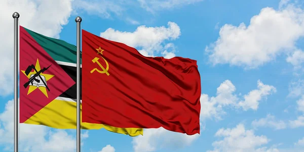 Moçambique e a bandeira da União Soviética agitando no vento contra o céu azul nublado branco juntos. Conceito de diplomacia, relações internacionais . — Fotografia de Stock