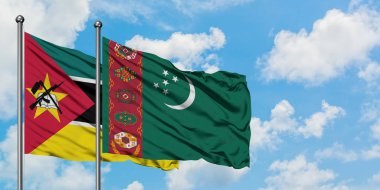 Mozambik ve Türkmenistan bayrağı birlikte beyaz bulutlu mavi gökyüzüne karşı rüzgarsal sallayarak. Diplomasi kavramı, uluslararası ilişkiler.