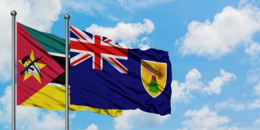 Mozambik ve Turks ve Caicos Adaları bayrağı birlikte beyaz bulutlu mavi gökyüzüne karşı rüzgarsal sallayarak. Diplomasi kavramı, uluslararası ilişkiler.