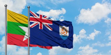 Myanmar ve Anguilla bayrağı birlikte beyaz bulutlu mavi gökyüzüne karşı rüzgarda sallayarak. Diplomasi kavramı, uluslararası ilişkiler.