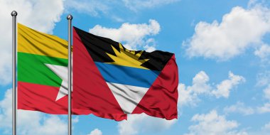 Myanmar ve Antigua ve Barbuda bayrağı birlikte beyaz bulutlu mavi gökyüzüne karşı rüzgarda sallayarak. Diplomasi kavramı, uluslararası ilişkiler.