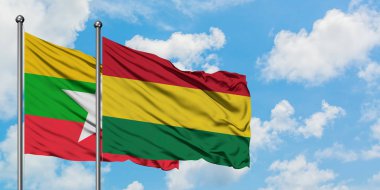 Myanmar ve Bolivya bayrağı birlikte beyaz bulutlu mavi gökyüzüne karşı rüzgarda sallayarak. Diplomasi kavramı, uluslararası ilişkiler.