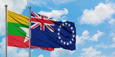 Myanmar ve Cook Adaları bayrağı birlikte beyaz bulutlu mavi gökyüzüne karşı rüzgarda sallayarak. Diplomasi kavramı, uluslararası ilişkiler.