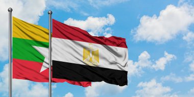 Myanmar ve Mısır bayrağı birlikte beyaz bulutlu mavi gökyüzüne karşı rüzgarsal sallayarak. Diplomasi kavramı, uluslararası ilişkiler.