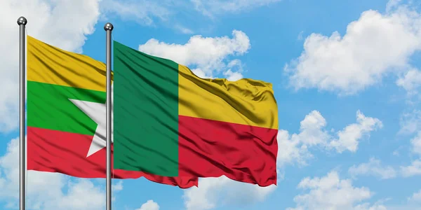 Bandera de Myanmar y Benín ondeando en el viento contra el cielo azul nublado blanco juntos. Concepto diplomático, relaciones internacionales . — Foto de Stock