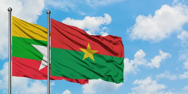 Bandera de Myanmar y Burkina Faso ondeando en el viento contra el cielo azul nublado blanco juntos. Concepto diplomático, relaciones internacionales . — Foto de Stock