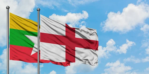 Myanmar és Anglia zászló integetett a szél ellen, fehér felhős kék ég együtt. Diplomáciai koncepció, nemzetközi kapcsolatok. — Stock Fotó