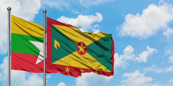 Bandera de Myanmar y Granada ondeando en el viento contra el cielo azul nublado blanco juntos. Concepto diplomático, relaciones internacionales . — Foto de Stock