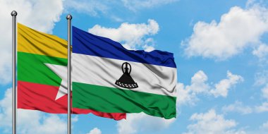 Myanmar ve Lesotho bayrağı birlikte beyaz bulutlu mavi gökyüzüne karşı rüzgarda sallayarak. Diplomasi kavramı, uluslararası ilişkiler.