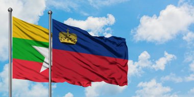 Myanmar ve Lihtenştayn bayrağı birlikte beyaz bulutlu mavi gökyüzüne karşı rüzgarda sallayarak. Diplomasi kavramı, uluslararası ilişkiler.