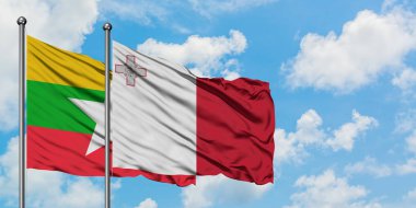 Myanmar ve Malta bayrağı birlikte beyaz bulutlu mavi gökyüzüne karşı rüzgarda sallayarak. Diplomasi kavramı, uluslararası ilişkiler.