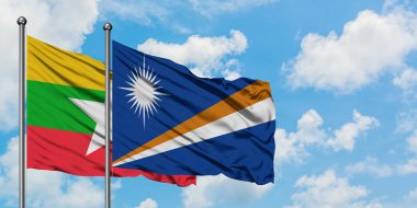 Myanmar ve Marshall Adaları bayrağı birlikte beyaz bulutlu mavi gökyüzüne karşı rüzgarda sallayarak. Diplomasi kavramı, uluslararası ilişkiler.