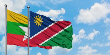 Myanmar ve Namibya bayrağı birlikte beyaz bulutlu mavi gökyüzüne karşı rüzgarda sallayarak. Diplomasi kavramı, uluslararası ilişkiler.