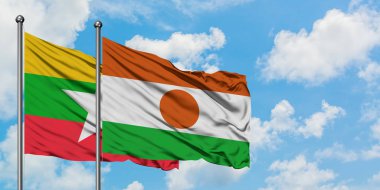 Myanmar ve Nijer bayrağı birlikte beyaz bulutlu mavi gökyüzüne karşı rüzgarda sallayarak. Diplomasi kavramı, uluslararası ilişkiler.