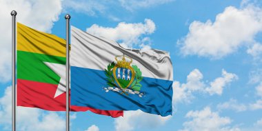 Myanmar ve San Marino bayrağı birlikte beyaz bulutlu mavi gökyüzüne karşı rüzgarda sallayarak. Diplomasi kavramı, uluslararası ilişkiler.