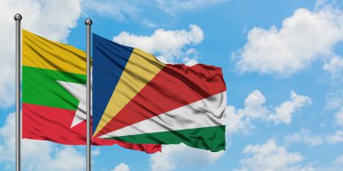 Myanmar ve Seyşeller bayrağı birlikte beyaz bulutlu mavi gökyüzüne karşı rüzgarda sallayarak. Diplomasi kavramı, uluslararası ilişkiler.