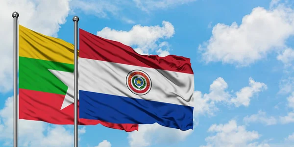 Bandera de Myanmar y Paraguay ondeando en el viento contra el cielo azul nublado blanco juntos. Concepto diplomático, relaciones internacionales . —  Fotos de Stock