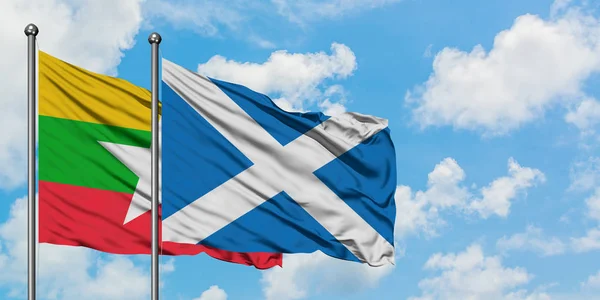 Myanmar and Scotland flag waving in the wind against white cloudy blue sky together. Diplomacy concept, international relations.