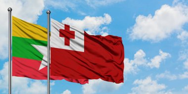 Myanmar ve Tonga bayrağı birlikte beyaz bulutlu mavi gökyüzüne karşı rüzgarda sallayarak. Diplomasi kavramı, uluslararası ilişkiler.