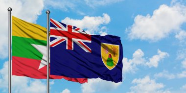 Myanmar ve Turks ve Caicos Adaları bayrağı birlikte beyaz bulutlu mavi gökyüzüne karşı rüzgarsal sallayarak. Diplomasi kavramı, uluslararası ilişkiler.