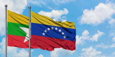 Myanmar ve Venezuela bayrağı birlikte beyaz bulutlu mavi gökyüzüne karşı rüzgarda sallayarak. Diplomasi kavramı, uluslararası ilişkiler.
