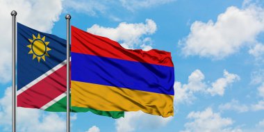 Namibya ve Ermenistan bayrağı birlikte beyaz bulutlu mavi gökyüzüne karşı rüzgarda sallayarak. Diplomasi kavramı, uluslararası ilişkiler.