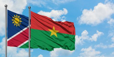 Namibya ve Burkina Faso bayrak birlikte beyaz bulutlu mavi gökyüzüne karşı rüzgarda sallayarak. Diplomasi kavramı, uluslararası ilişkiler.