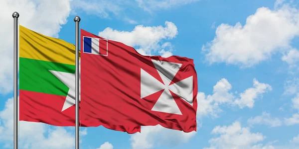 Myanmar y Wallis Y la bandera de Futuna ondeando en el viento contra el cielo azul nublado blanco juntos. Concepto diplomático, relaciones internacionales . — Foto de Stock