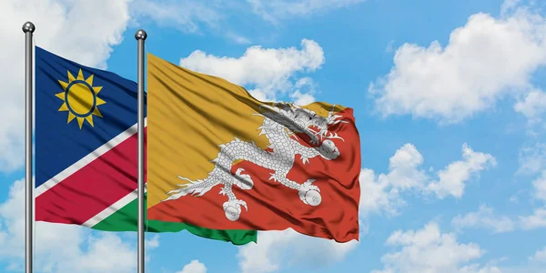 Namibia and Bhutan flag waving in the wind against white cloudy blue sky together. Diplomacy concept, international relations. — Stock Photo, Image