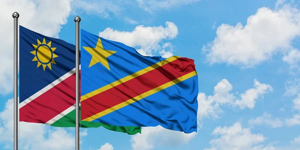 Bandera de Namibia y Congo ondeando en el viento contra el cielo azul nublado blanco juntos. Concepto diplomático, relaciones internacionales . — Foto de Stock
