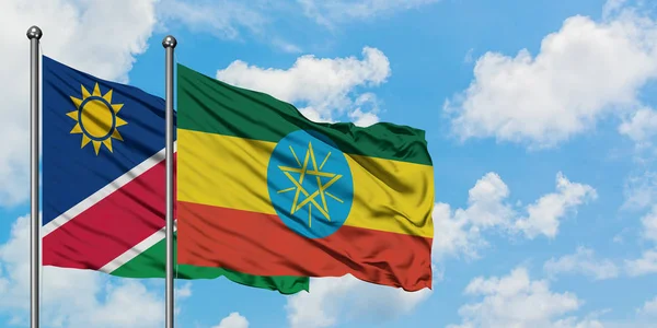 Namibia and Ethiopia flag waving in the wind against white cloudy blue sky together. Diplomacy concept, international relations. — Stock Photo, Image