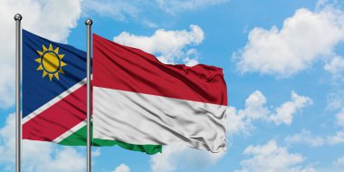 Namibya ve Endonezya bayrağı birlikte beyaz bulutlu mavi gökyüzüne karşı rüzgarda sallayarak. Diplomasi kavramı, uluslararası ilişkiler.