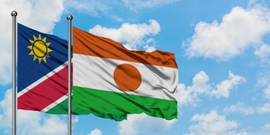 Namibya ve Nijer bayrağı birlikte beyaz bulutlu mavi gökyüzüne karşı rüzgarda sallayarak. Diplomasi kavramı, uluslararası ilişkiler.